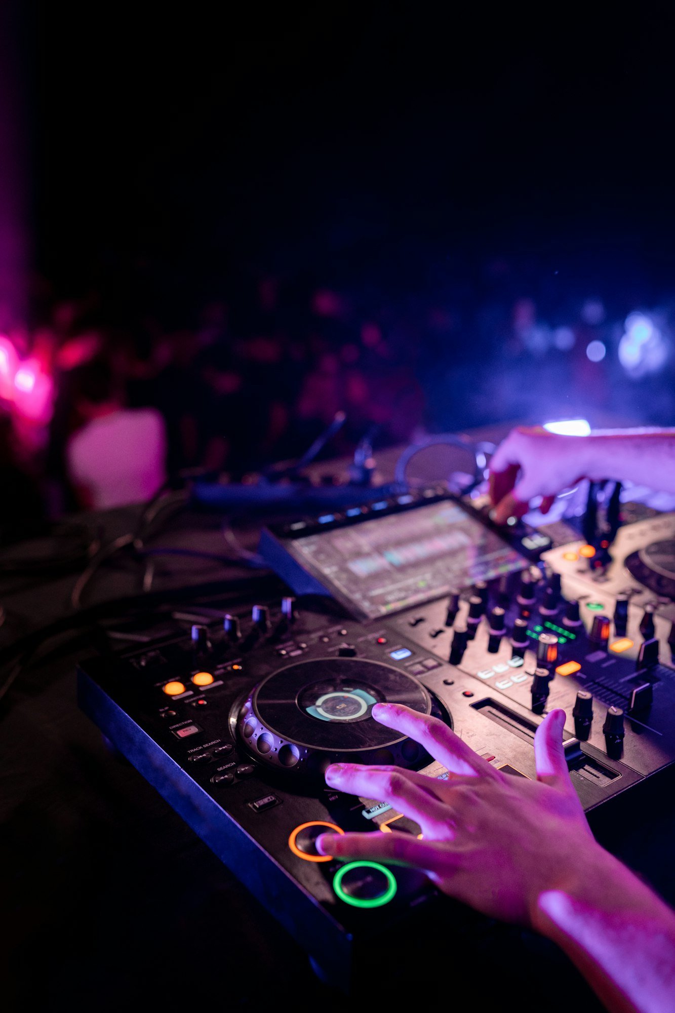 Hands of DJ performing in stage in a disco